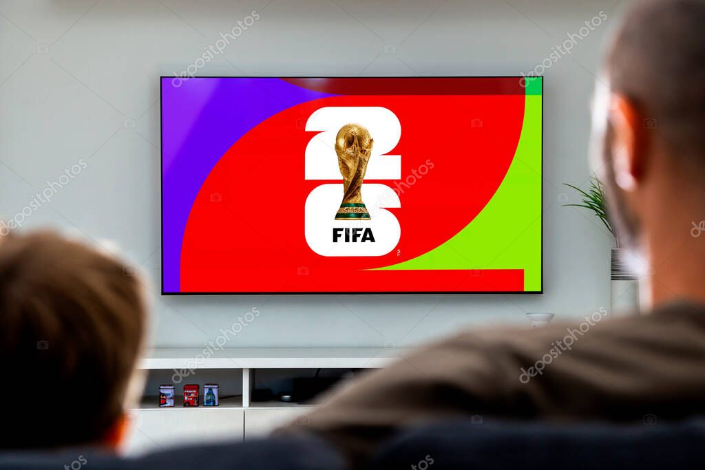 Man and his son looking a smart TV with the FIFA World Cup 2026 the screen. Rosario, Argentina - April 12, 2025.