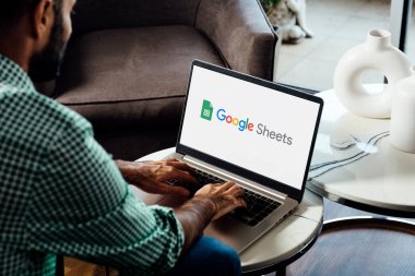 Google Sheets 'in logosunu ekranda gösteren bir dizüstü bilgisayar kullanan adam. Hesaplama, formüller ve verimlilik için çevrimiçi hesap tablosu yazılımı. ROSARIO, ARJANTINA - 17 Nisan 2025