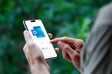 Microsoft 'un e-postası için Outlook uygulamasını açan bir adam. ROSARIO, ARJANTINA - 30 Nisan 2025.