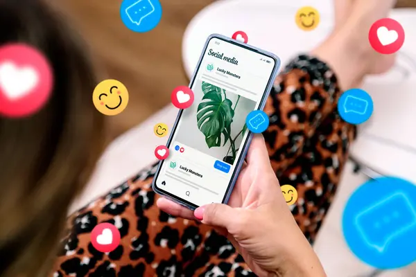 Cep telefonu ekranında emojili sosyal medya reklamları. Akıllı telefonlu bir kadın sosyal medya reklamı örneği gösteriyor..