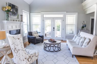 A light and bright open concept living room den with vaulted ceilings in a new construction house with a set of double glass doors to the patio.