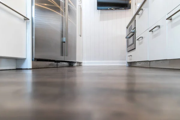 Dark wood hardwood floors in a newly renovated white cabinet modern kitchen.