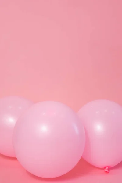 Light pink balloons on a pink backdrop with copy space for a birthday, party, celebration, event or party.