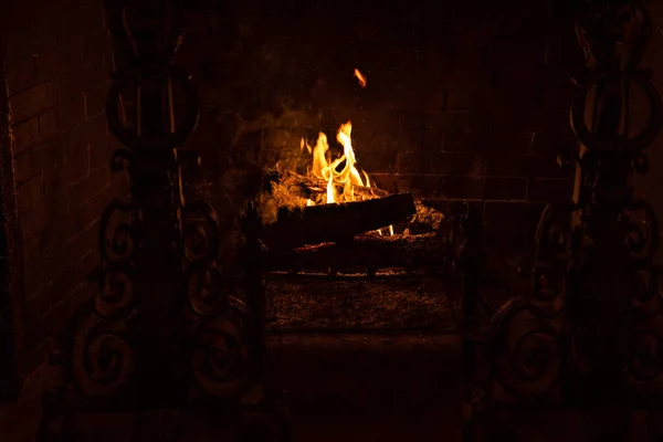 金属製の暖炉の火格子で暖炉を燃やす木のオレンジの炎と轟音室内火災 — ストック写真