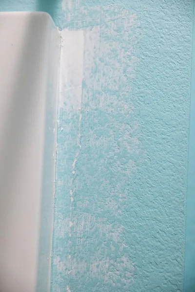 在蓝色水族馆结构的墙壁和淋浴浴缸之间的一个浴室壁上的裂缝 已经被填满并被弯曲 已经准备好被粉刷 — 图库照片