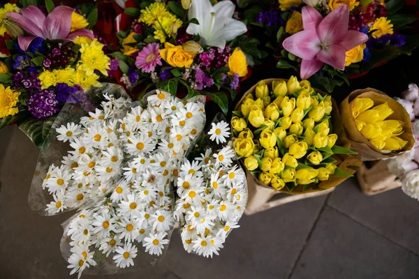 Large bouquets of colorful flowers wrapped up at a grab and go outdoor flower shop market in Rome Italy.