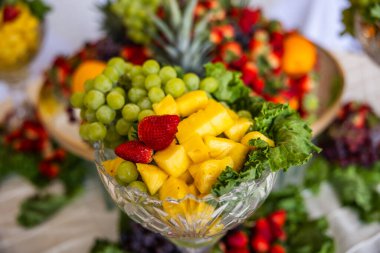 Büyük tepsi taze meyve ananas, yeşil üzüm, çilek ve diğer meyveleri de içerir..