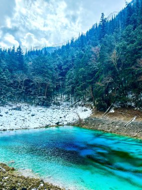 Huzurlu Alp Kaçışı: Kar Tozlu Evergreens 'in Ortasında Kristal Berraklığında Bir Göl
