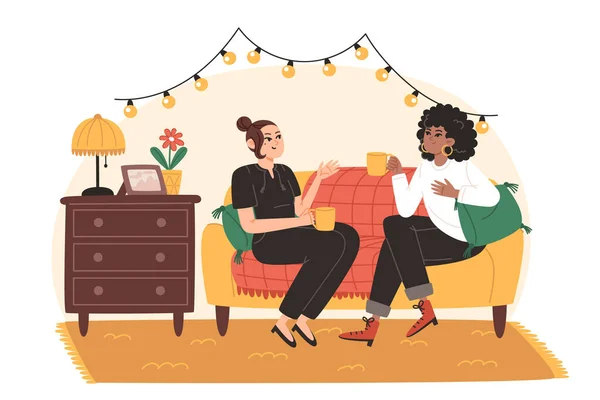 Genç kadınlar oturma odasındaki rahat bir kanepede oturmuş neşeyle konuşuyorlar.