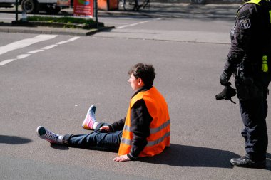 Berlin, Almanya - 24 Nisan 2023: Son Nesil grubundan protestocular sokakta oturup Berlin, Hermannplatz 'da trafiği engelliyor. Yüksek kalite fotoğraf