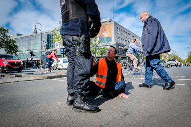 Berlin, Almanya - 24 Nisan 2023: Son Nesil grubundan protestocular sokakta oturup Berlin, Hermannplatz 'da trafiği engelliyor. Yüksek kalite fotoğraf