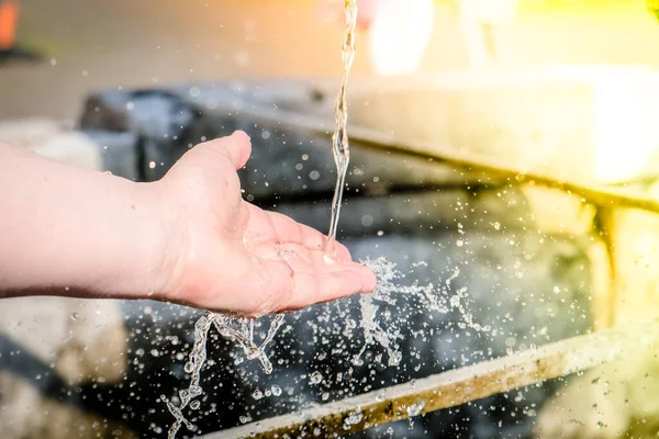 町の噴水で女の子の手と流れる水 高品質の写真 — ストック写真
