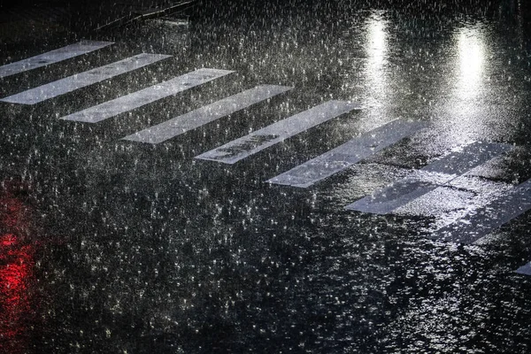 Heavy rains, showers in the city, rain and water in the street in the evening, flooding of the streets. High quality photo