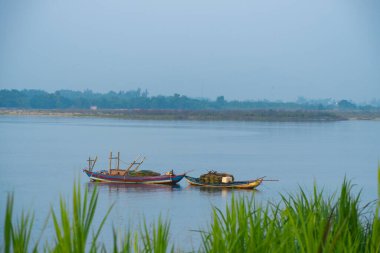 Vietnamlı çiftçilerin tekneleri sabahları nehre demirliyor. Sessiz nehrin doğa sembolü..
