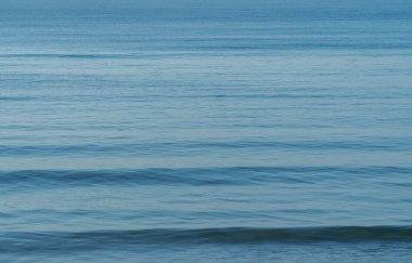Sakin deniz yüzeyinin arkaplan görüntüsü ve birkaç dalga, tekne yok..