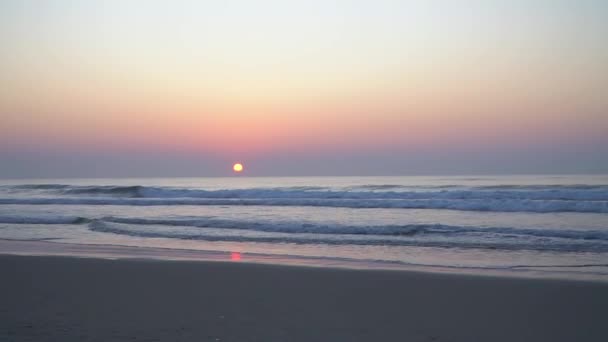 在沙滩上的日出景观视频 海浪和升起的太阳笼罩在薄雾中 天空无云 伴随着海浪和风的声音 — 图库视频影像