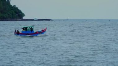Küçük balıkçı tekneleri ve deniz ağzında ileri geri koşan Vietnamlı balıkçı tekneleri olan deniz burnu. Sa Ky haliçleri, Quang Ngai. Denizde çalışmak. Tekneler yelken açtı. Deniz feneri. 