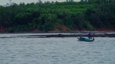 Küçük balıkçı tekneleri ve deniz ağzında ileri geri koşan Vietnamlı balıkçı tekneleri olan deniz burnu. Sa Ky haliçleri, Quang Ngai. Denizde çalışmak. Tekneler yelken açtı. Deniz feneri. 