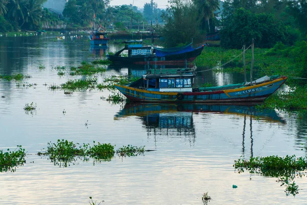 stock image Quang Ngai, Vietnam - June 13, 2023: A Vietnamese fisherman's fishing boat is moored on a calm river with a reflection on the water.