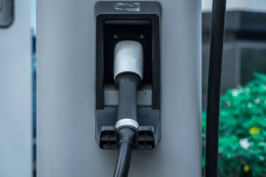 Elektrikli taşıt şarj istasyonunda elektrik kablosu ve bağlantı noktası yüklü bir EV şarj istasyonu. Sürdürülebilir ve çevre dostu enerji kavramı.