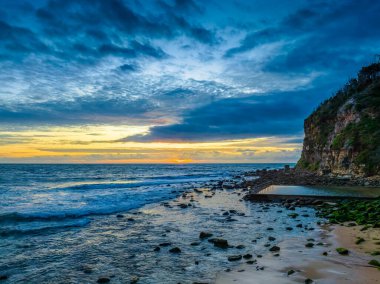 Deniz kıyısında hava gündoğumu bulutlar ve dalgalar ile Central Coast, NSW, Avustralya 'daki Macmaster Sahili' nde.