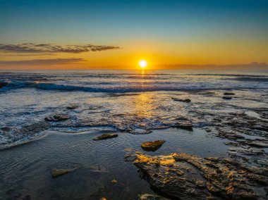 Newcastle, NSW, Avustralya 'daki Düz Kaya plajında güneş doğuyor..