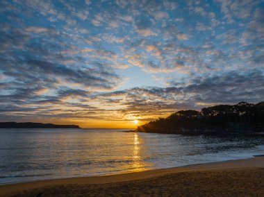 Gündoğumu, deniz ve bulutlar Pearl Beach 'ten Central Coast, NSW, Avustralya.