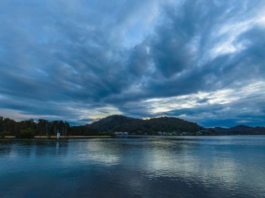 Yağmur bulutları, sis ve Woy Woy 'daki yansımalarla birlikte NSW, Avustralya.
