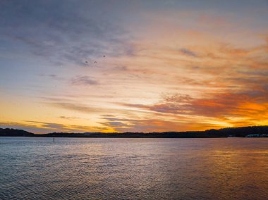 Woy Woy körfezinde, NSW, Avustralya 'da yüksek bulutlu hava gündoğumu su manzarası..