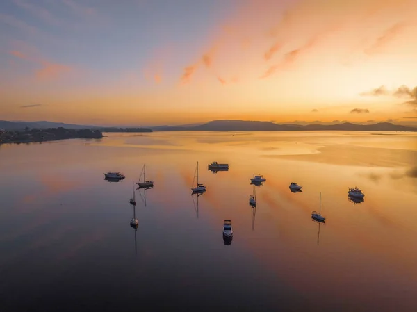 stock image Soft and dreamy sunrise over Brisbane Water with clouds, fog and boats at Koolewong and Tascott on the Central Coast, NSW, Australia.