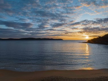 Gündoğumu, deniz ve bulutlar Pearl Beach 'ten Central Coast, NSW, Avustralya.