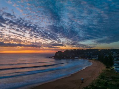 Orta büyüklükteki bulutlarla birlikte deniz kıyısında hava gündoğumu Orta Sahildeki Avoca Sahili 'nde, NSW, Avustralya.