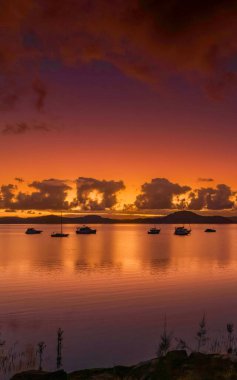 Gündoğumu, bulutlar ve tekne yansımaları Brisbane 'de Koolewong' da ve Tascott 'ta merkez sahilde, NSW, Avustralya.