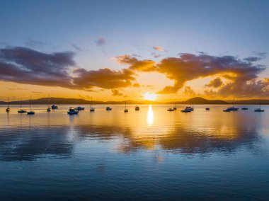 Gündoğumu, bulutlar ve tekne yansımaları Brisbane 'de Koolewong' da ve Tascott 'ta merkez sahilde, NSW, Avustralya.