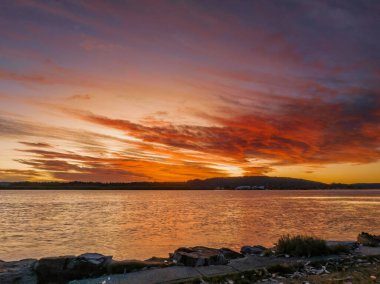 Woy Woy körfezinde, NSW, Avustralya 'da yüksek bulutlu hava gündoğumu su manzarası..