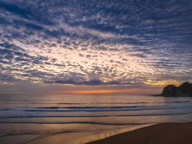 Orta büyüklükteki bulutlarla birlikte deniz kıyısında hava gündoğumu Orta Sahildeki Avoca Sahili 'nde, NSW, Avustralya.