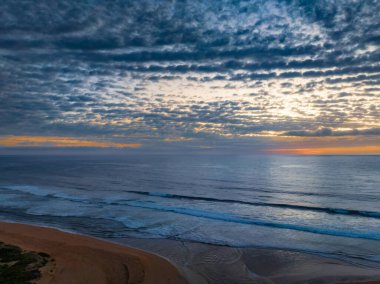 Orta büyüklükteki bulutlarla birlikte deniz kıyısında hava gündoğumu Orta Sahildeki Avoca Sahili 'nde, NSW, Avustralya.