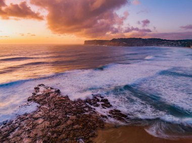 Bulutları, kaya platformları, iyi boyutta dalgaları ve NSW, Avustralya 'daki Kuzey Avoca Sahili' nde bolca atmosferi olan hava gündoğumu deniz manzarası..