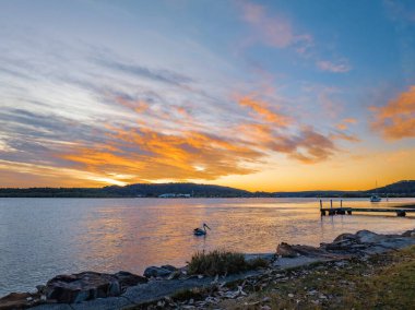 Woy Woy körfezinde, NSW, Avustralya 'da yüksek bulutlu hava gündoğumu su manzarası..