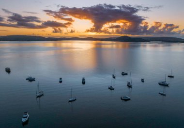 Gündoğumu, bulutlar ve tekne yansımaları Brisbane 'de Koolewong' da ve Tascott 'ta merkez sahilde, NSW, Avustralya.