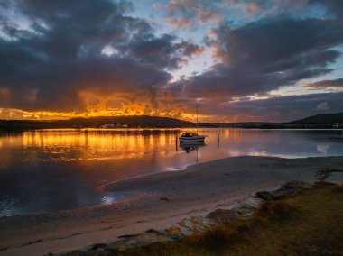 Orta Sahildeki Woy Woy, NSW, Avustralya 'da güneşin doğuşunu kaplayan bir bulut..