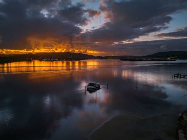 Orta Sahildeki Woy Woy, NSW, Avustralya 'da güneşin doğuşunu kaplayan bir bulut..