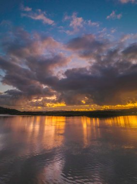 Orta Sahildeki Woy Woy, NSW, Avustralya 'da güneşin doğuşunu kaplayan bir bulut..