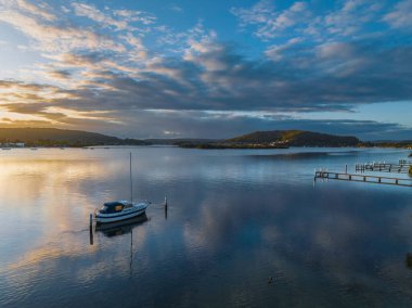 Orta Sahildeki Woy Woy, NSW, Avustralya 'da güneşin doğuşunu kaplayan bir bulut..