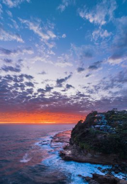 Central Coast, NSW, Avustralya 'daki Avoca Sahili' nde bulutlu, sörf ve atmosferli gün doğumu deniz manzarası.