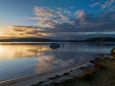Orta Sahildeki Woy Woy, NSW, Avustralya 'da güneşin doğuşunu kaplayan bir bulut..