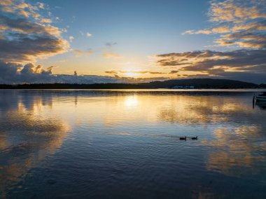Orta Sahildeki Woy Woy, NSW, Avustralya 'da güneşin doğuşunu kaplayan bir bulut..