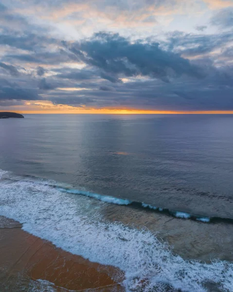 Sunrise seascape with colour and clouds at Killcare Beach on the Central Coast, NSW, Australia.