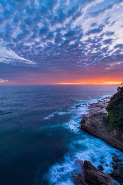 Central Coast, NSW, Avustralya 'daki Avoca Sahili' nde bulutlu, sörf ve atmosferli gün doğumu deniz manzarası.