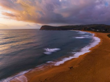 Central Coast, NSW, Avustralya 'daki Copacabana' da yağmur bulutlarıyla gün doğumu denizi.